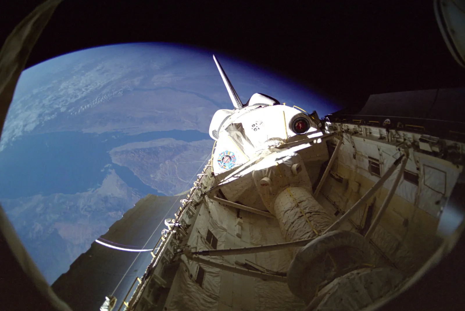 Space Shuttle Discovery's open payload bay in orbit during STS-42, the white International Microgravity Laboratory Spacelab module against Earth and black space.