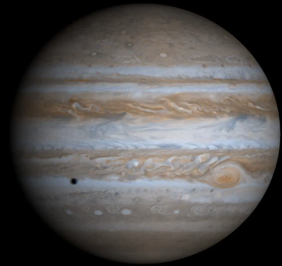 Jupiter in natural color from Cassini, with cream, rust, and white cloud bands.