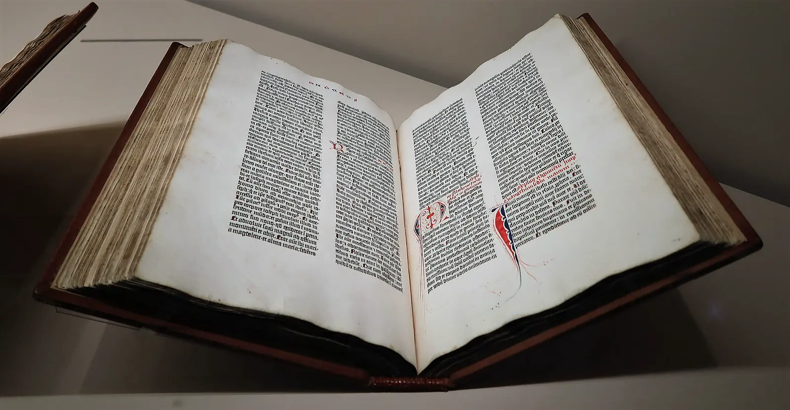 An open Gutenberg Bible, the 42-line edition, pages standing open on a lectern.