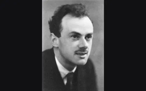 A 1933 black-and-white portrait of Paul Dirac, in a dark suit and patterned tie.