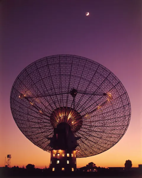The Parkes radio telescope at night, the dish turned toward a bright moon.