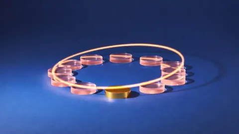 A ring of unmarked glass counters with one gold counter, generated image