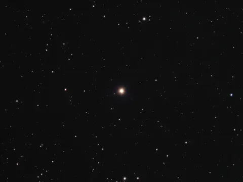 The orange giant 42 Draconis, the star named Fafnir, shining alone in a dark field of fainter stars.