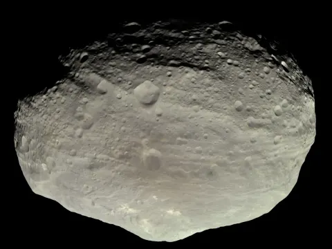 Asteroid 4 Vesta in natural color, craters lit by the Sun.